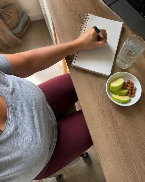 Escritorio con cuaderno, manzana y almendras