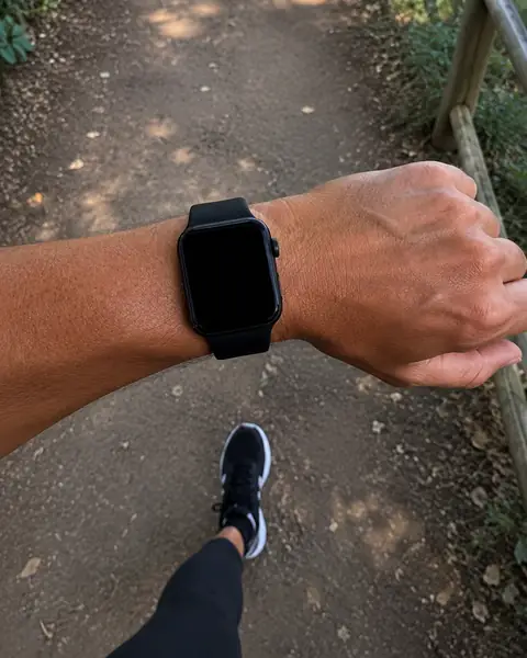 Caminata por un sendero al sol, con reloj en la muñeca