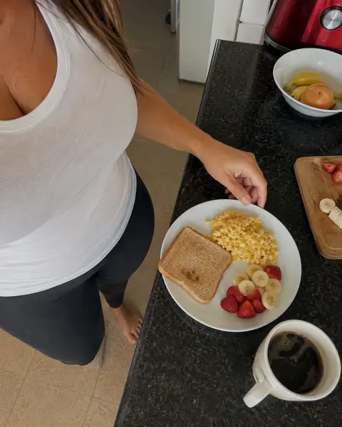 Desayuno con tostada, huevo, frutillas, banana y café